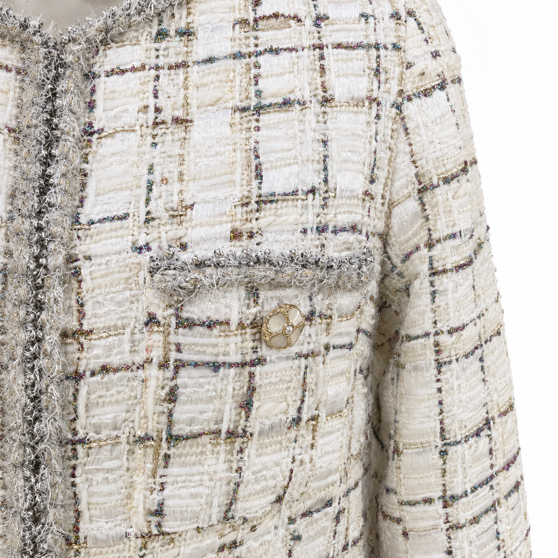Close-up of ivory checked tweed and silver-grey fringe neckline