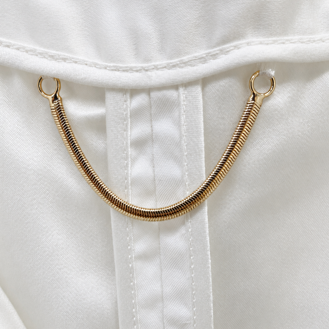 Interior lining and gold-tone hanging chain of ivory tweed jacket