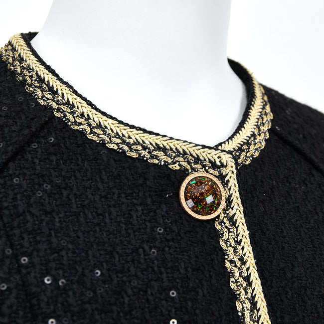 Collarless round neckline with cream-gold braided trim and an amber-toned button
