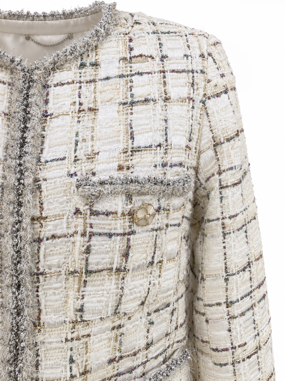 Close-up of ivory checked tweed and silver-grey fringe neckline