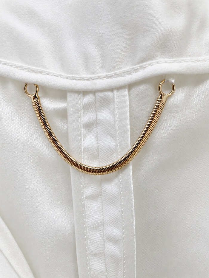 Interior lining and gold-tone hanging chain of ivory tweed jacket