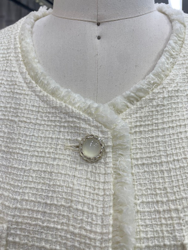 Fringe trim around the round neckline of the 70816 white tweed vest