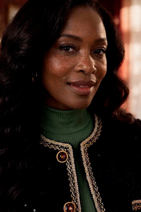 Campaign model in the jacket over a green top at a celebration